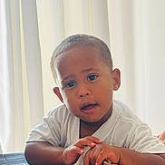 Adael is registered to the contest to win money with this photo: baby, candid, child, closeup, curtains, cute, expression, face, hands, indoor, looking, person, portrait, resting, short_hair, skin, soft_light, toddler, white_shirt, young_child