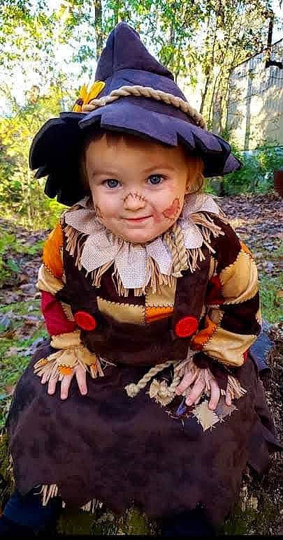 Callie joined the competition — help win amazing prizes! botany, child, costume_hat, doll, dress, face, fictional_character, grass, hat, headgear, joy, lawn_ornament, leaf, people_in_nature, person, pink, plant, purple, sun_hat, toddler