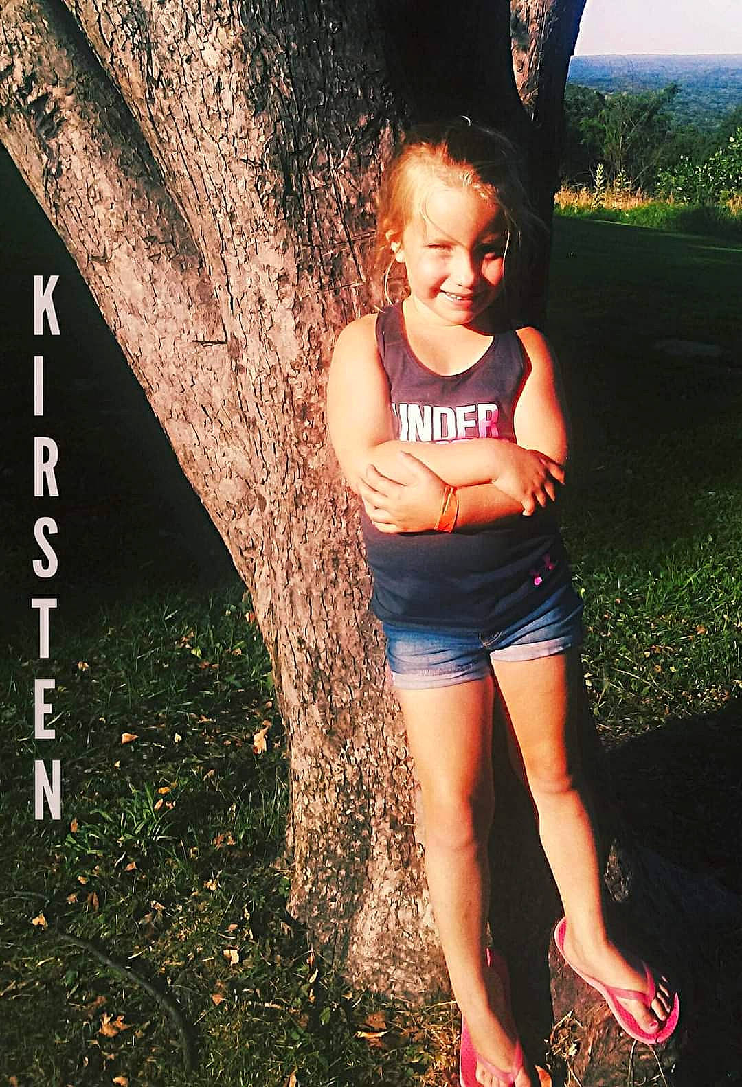 Kirsten is registered to the contest to win money with this photo: cool, eye, flash_photography, grass, happy, head, human_body, joy, knee, leg, leisure, natural_environment, people_in_nature, person, plant, shorts, smile, thigh, tree, trunk