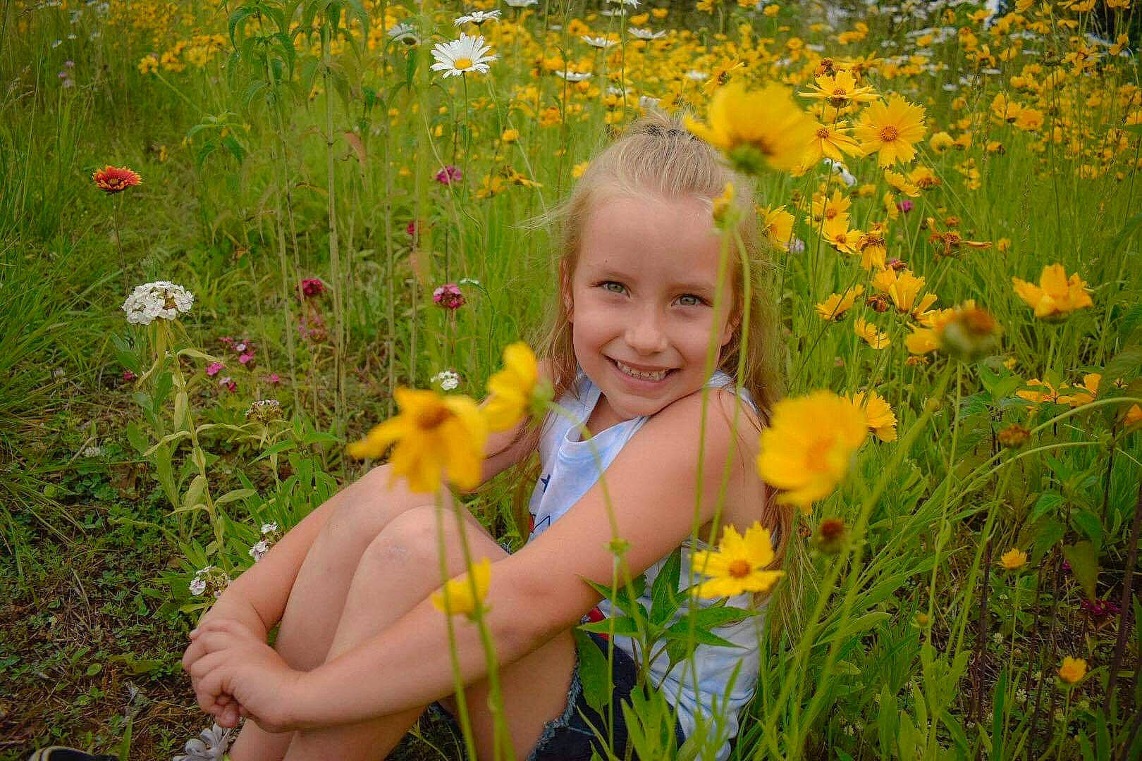 Kirsten is registered to the contest to win money with this photo: ecoregion, field, flower, flowering_plant, grass, grass_family, grassland, happy, herbaceous_plant, joy, meadow, natural_environment, natural_landscape, people_in_nature, person, petal, plant, prairie, smile, summer