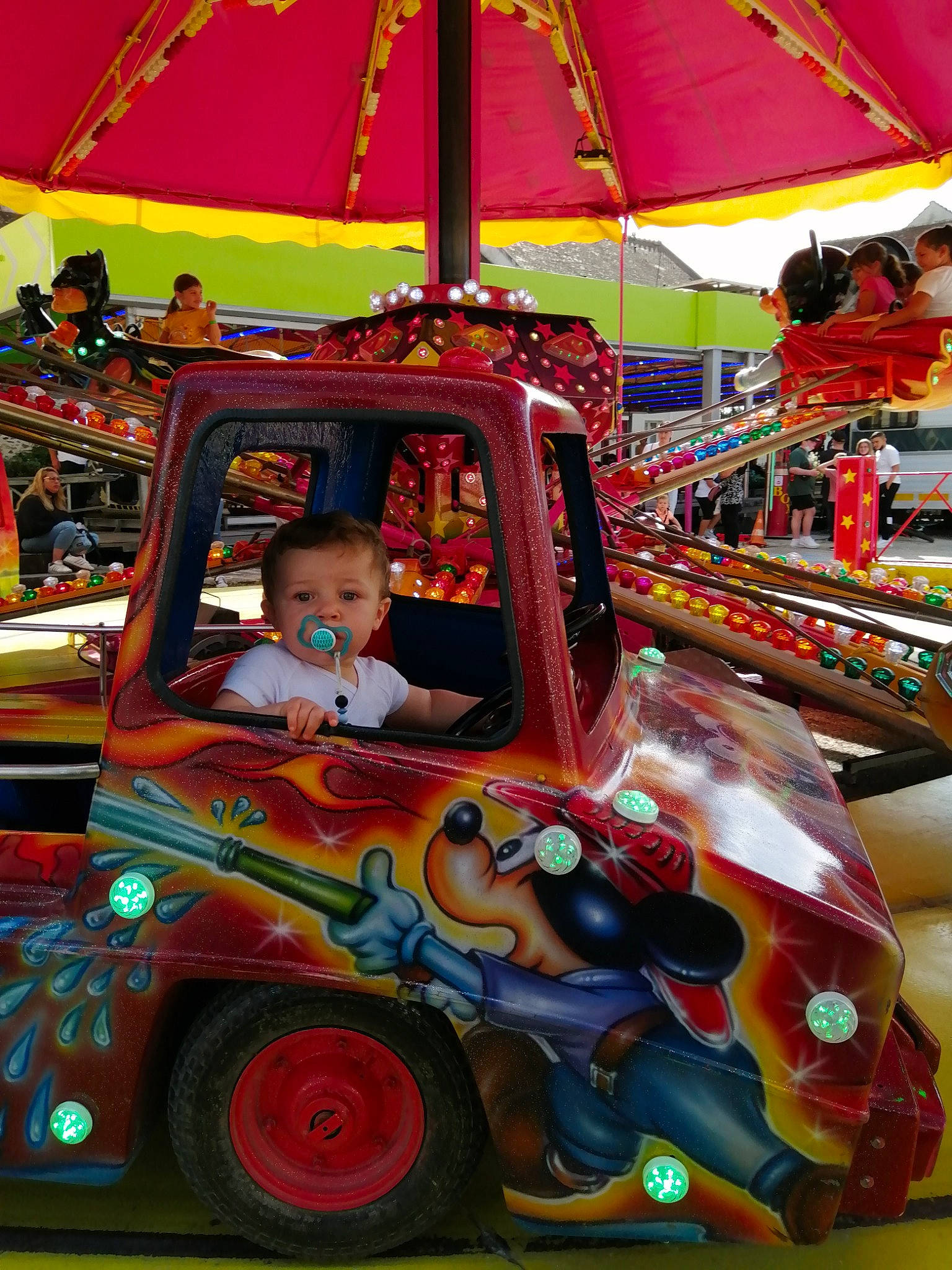 Lenzo a rejoint le concours — aidez-le/la à gagner de superbes lots ! amusement_ride, automotive_design, automotive_exterior, bumper, car, entertainment, fun, leisure, light, mode_of_transport, motor_vehicle, person, public_space, recreation, red, riding_toy, tire, toddler, under_exposed, vehicle