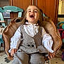 Lya participe au concours pour gagner de l'argent avec cette photo : child, toddler, laughing, smiling, plush_chair, checkered_outfit, white_blouse, indoor, toy, furniture, floor_mat, happy, person, home, playroom, hair_tied, cute, cozy, seated, expression