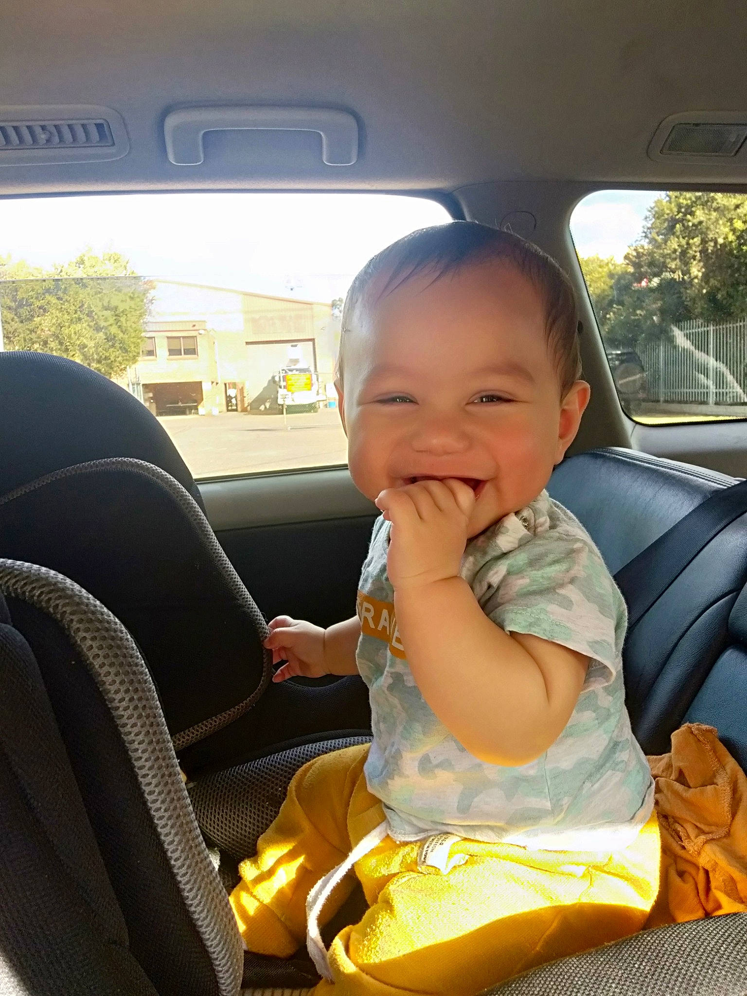 Remus is registered to the contest to win money with this photo: automotive_design, automotive_exterior, automotive_mirror, baby_toddler_clothing, car, car_seat, car_seat_cover, comfort, head_restraint, joy, mode_of_transport, motor_vehicle, person, seat_belt, smile, steering_part, steering_wheel, toddler, tree, vehicle