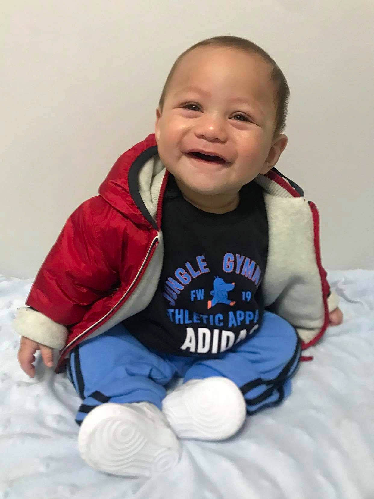 Remus is registered to the contest to win money with this photo: arm, baby, baby_products, baby_safety, baby_toddler_clothing, cheek, child, comfort, electric_blue, fun, happy, jacket, joy, person, personal_protective_equipment, sitting, skin, sleeve, smile, t_shirt