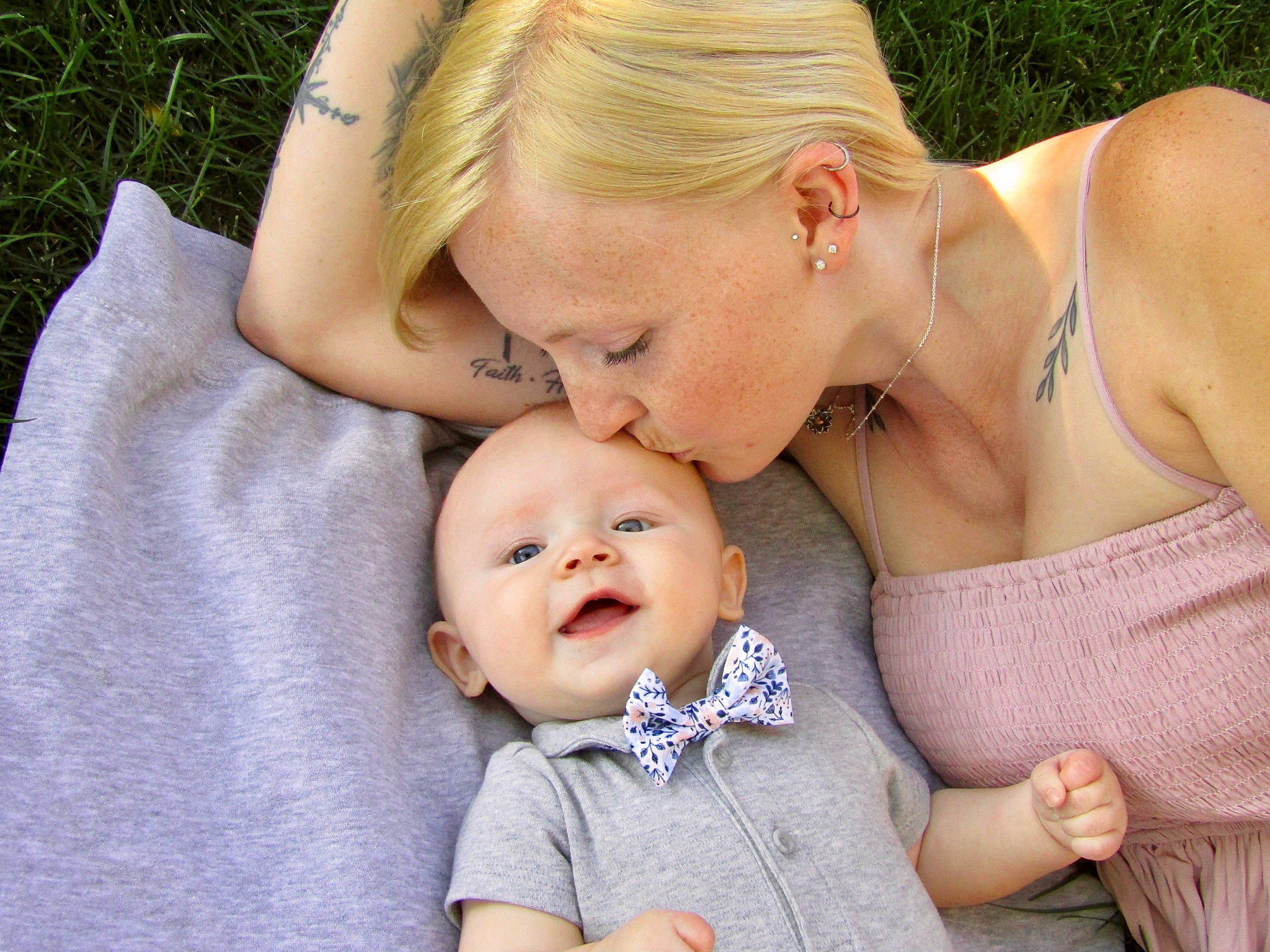 Ezra is registered to the contest to win money with this photo: baby, baby_toddler_clothing, cheek, chest, child, comfort, gesture, grass, hairstyle, happy, hug, interaction, jewellery, kiss, love, person, portrait_photography, sitting, skin, toddler