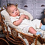 baby, blanket, blue_socks, child, cozy, cute, decor, furniture, indoor, infant, portrait, resting, smiling, soft_toys, teddy_bear, vintage, warm_lighting, white_clothing, wicker_carriage, wooden_floor