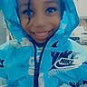 child, smiling, hoodie, blue_clothing, nike, indoor, face, person, portrait, happy, hands, jacket, young_child, casual_wear, cute, fashion, closeup, apparel, childhood, playful
