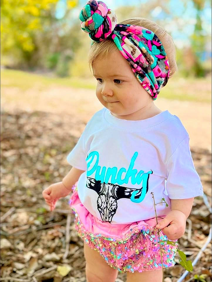 Paislee is registered to the contest to win money with this photo: baby_toddler_clothing, clothing, cool, grass, green, happy, head, headwear, magenta, neck, outerwear, pattern, people_in_nature, person, photograph, pink, sleeve, smile, summer, t_shirt