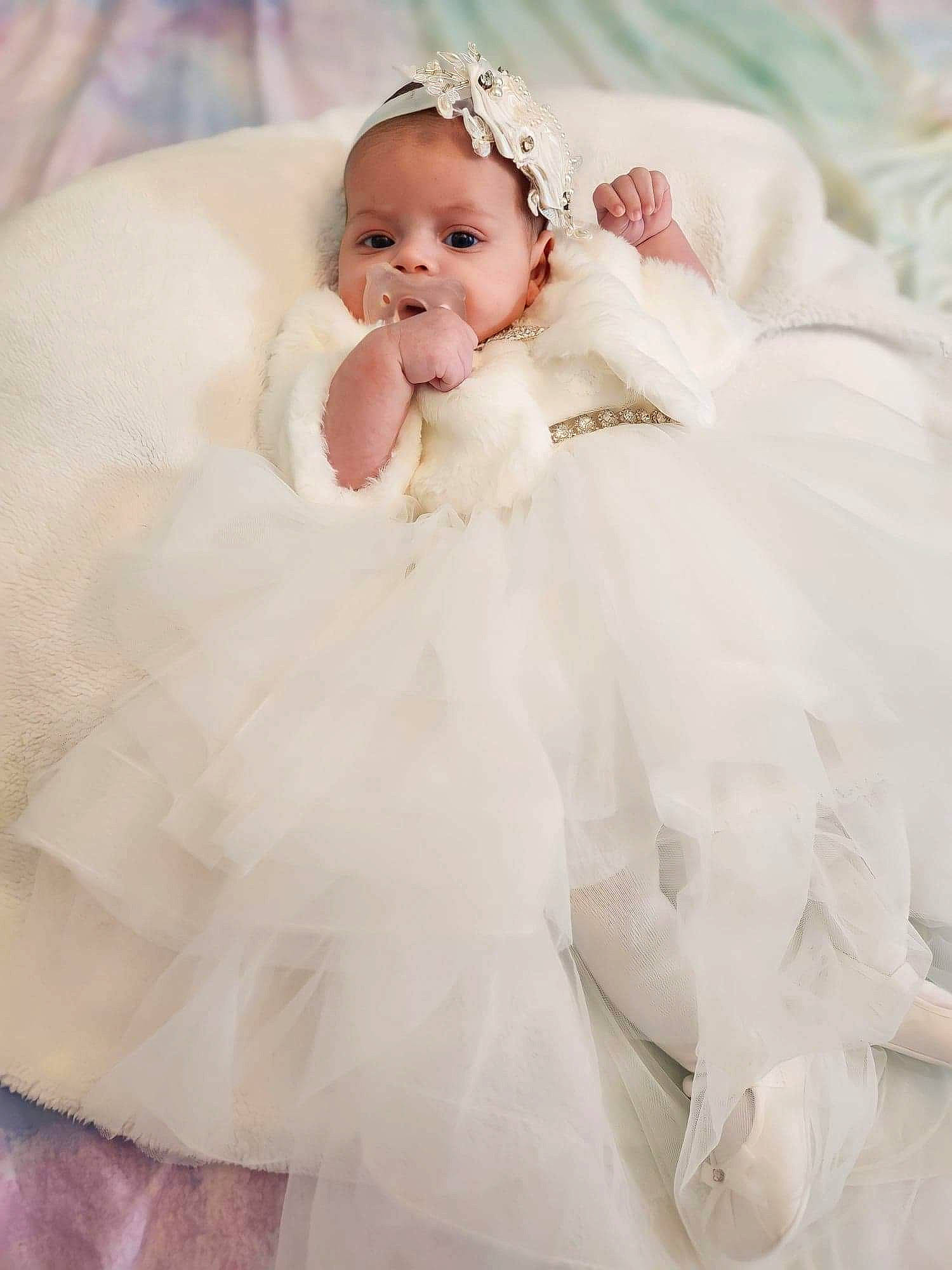 Kira is registered to the contest to win money with this photo: baby, baby_toddler_clothing, bridal_accessory, bridal_clothing, bridal_party_dress, dress, embellishment, event, flash_photography, gown, happy, headgear, headpiece, iris, jewellery, person, petal, pink, smile, toddler