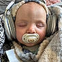 face, head, person, photography, portrait, electronics, baby, headphones, sleeping, blanket, homedecor, clothing, coat, jacket, newborn, cushion, hood, knitwear, sweater, bonnet