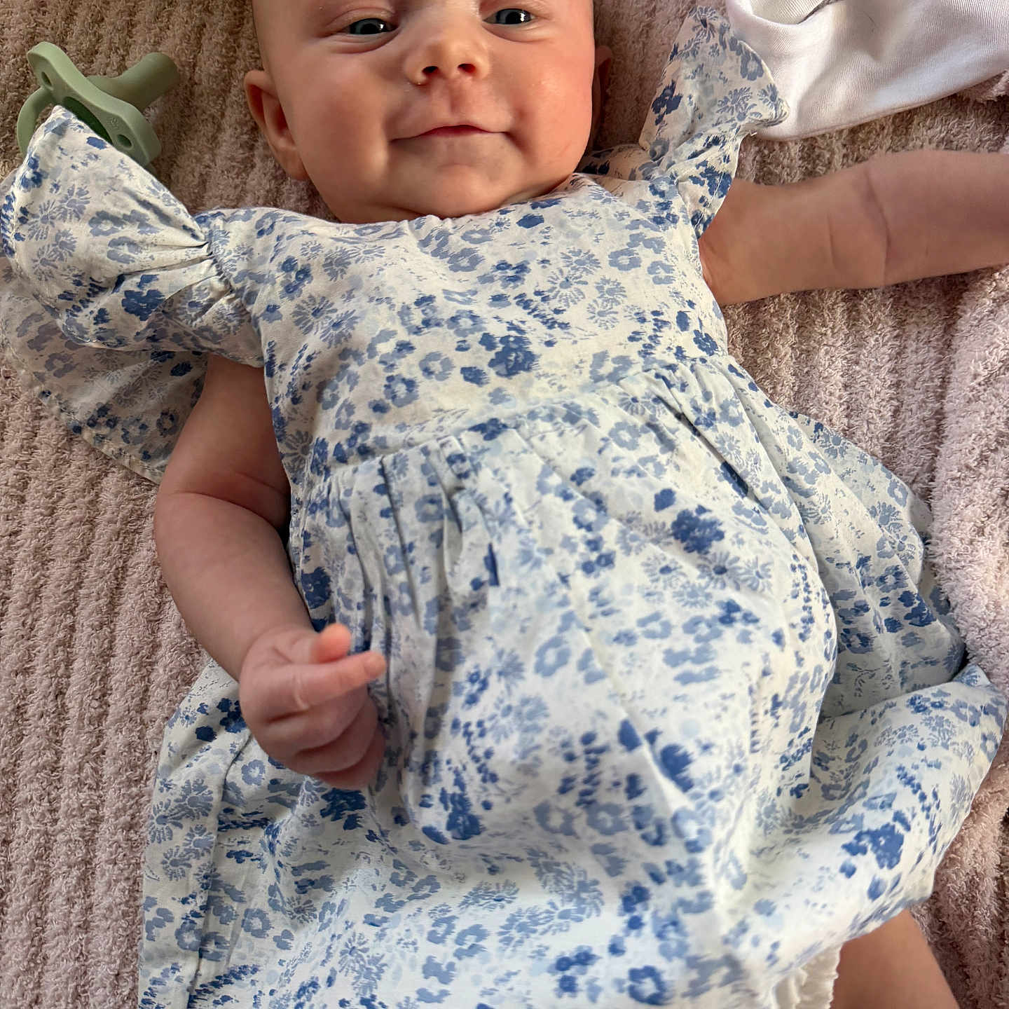 Swayze Layne joined the competition — help win amazing prizes! baby, infant, child, smile, dress, floral_pattern, blanket, pacifier, lying_down, cute, soft_texture, happy, skin, cute_face, clothing, indoor, newborn, adorable, portrait, baby_girl