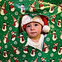 celebration, child, christmas, curious, cute, face, festive, green, hat, holiday, holiday_season, indoors, portrait, red, santa_hat, snowman_pattern, toddler, white, winter, wrapping_paper