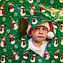 Cannon joined the competition — help win amazing prizes! celebration, child, christmas, curious, cute, expression, face, festive, green_background, holiday, holiday_decor, indoor, peek, portrait, red_and_white, santa_hat, snowman, toddler, winter, wrapping_paper