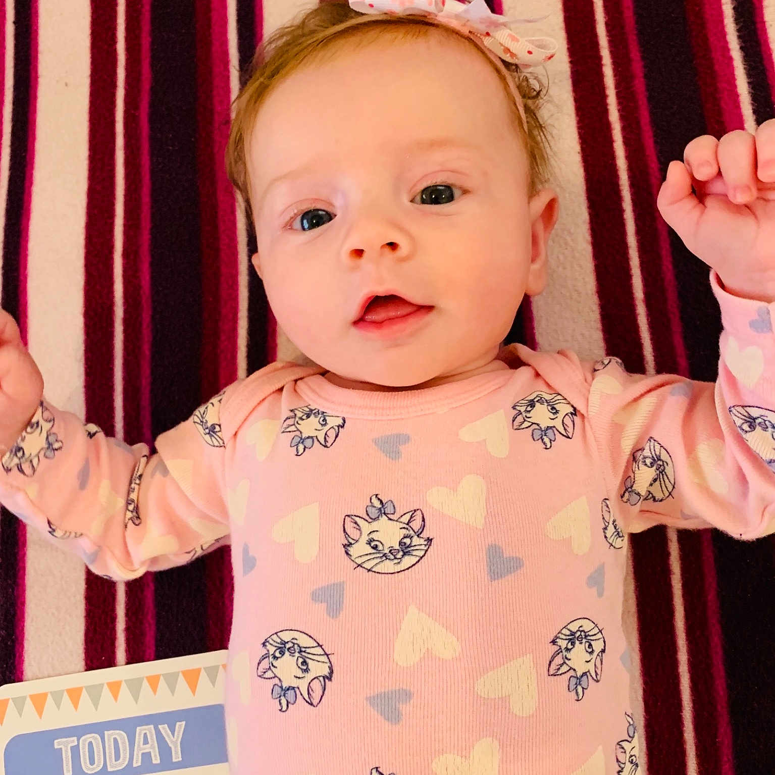 Meghan is registered to the contest to win money with this photo: baby, beauty, cheek, child, daughter, face, gesture, hand, head, nose, person, pink, product, room, skin, smile, toddler