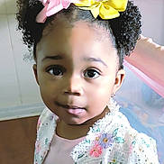 Vision is registered to the contest to win money with this photo: toddler, child, girl, curly_hair, hair_bows, pink_bow, yellow_bow, floral_jacket, sequins, indoor, portrait, face, big_eyes, cute, curious, person, fashion, young_child, smiling, playful