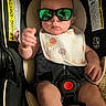 baby, child, car_seat, sunglasses, bib, polka_dots, infant, seatbelt, reflection, serious_face, hand, clothing, indoor, cute, baby_boy, closeup, safety, accessory, portrait, seat