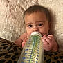 baby, bottle, milk, infant, bed, pillow, blanket, hand, face, eyes, skin, cute, child, feeding, indoors, rest, comfort, closeup, person, young
