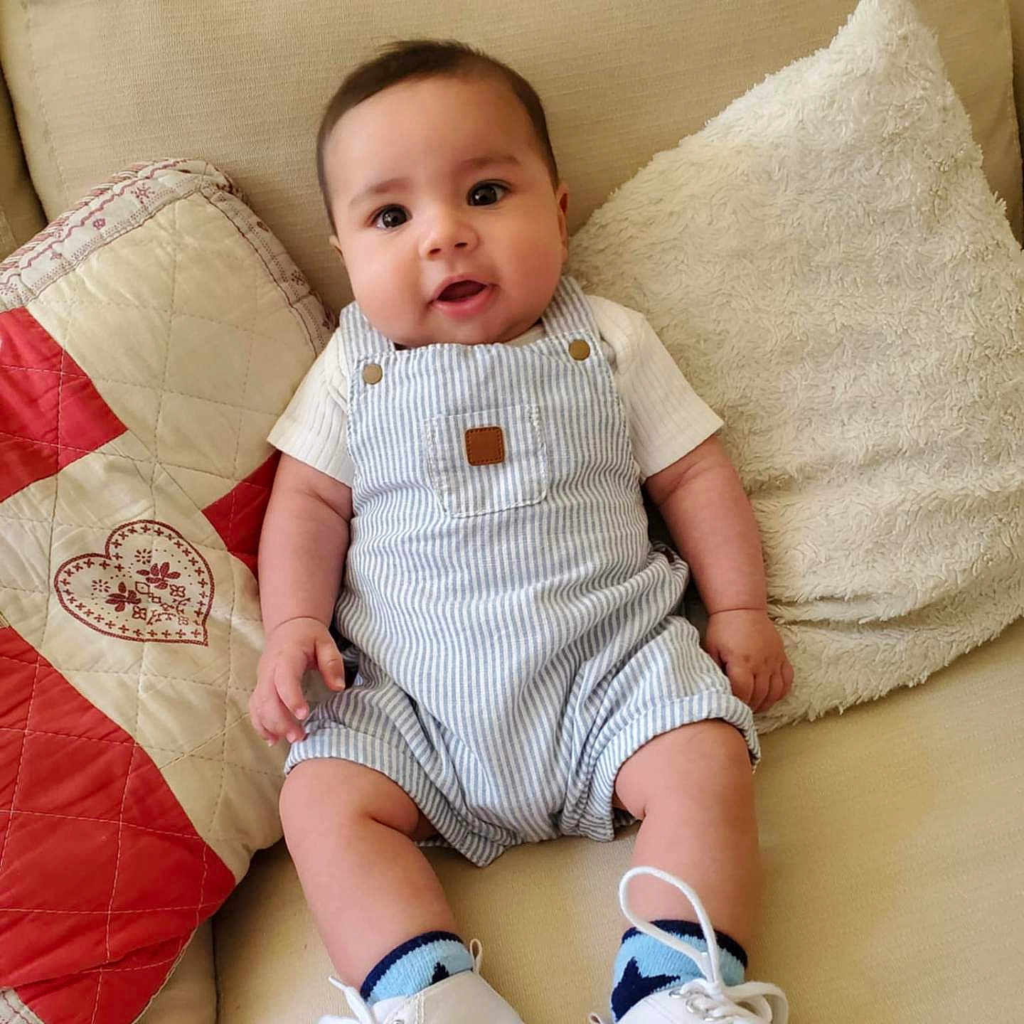 Maher a rejoint le concours — aidez-le/la à gagner de superbes lots ! baby, child, comfortable, couch, cozy, cute, footwear, furniture, happy, home, indoors, infant, overalls, pillow, portrait, sitting, smiling, soft_lighting, striped_clothing, white_shoes