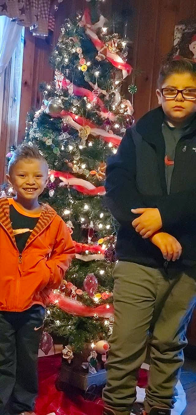 Easton is registered to the contest to win money with this photo: christmas, christmas_decoration, christmas_ornament, christmas_tree, event, evergreen, fun, glasses, happy, holiday, holiday_ornament, joy, ornament, outerwear, people, person, plant, sleeve, smile, standing