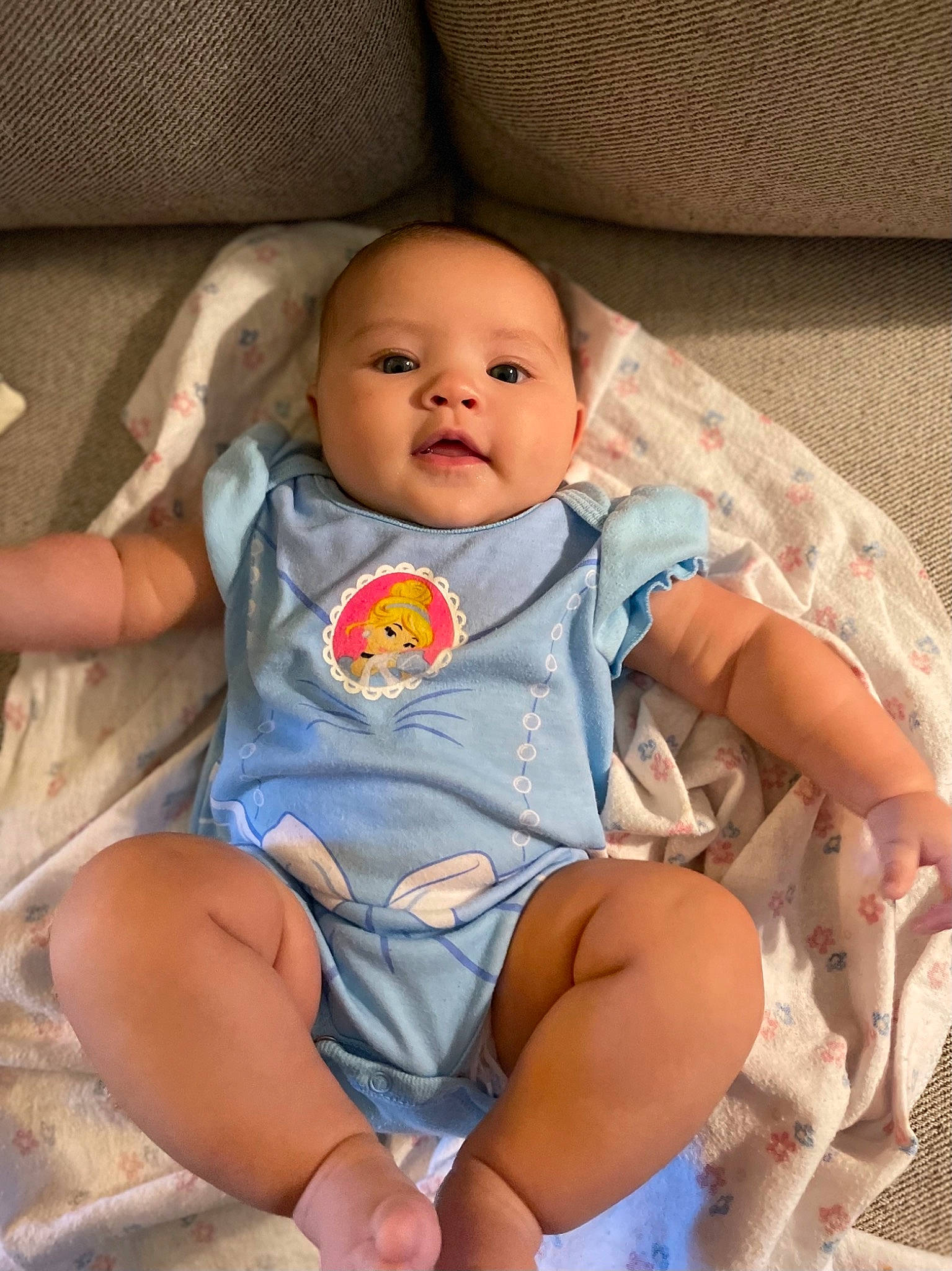 Regina is registered to the contest to win money with this photo: baby, baby_toddler_clothing, cheek, child, comfort, eye, face, facial_expression, finger, head, iris, mouth, person, product, sitting, skin, sleeve, smile, textile, thigh