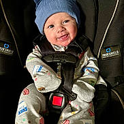 Levi joined the competition — help win amazing prizes! baby, infant, car_seat, blue_hat, onesie, smiling, cute, child, safety_harness, black_car_seat, patterned_clothing, happy, indoors, seatbelt, small_child, adorable, playful, headwear, baby_clothes, toddler