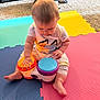 baby, child, toy, drum, colorful, foam_mat, indoor, carpet, sitting, play, musical_instrument, cute, infant, focus, clothing, floor, hand, foot, person, young