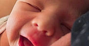 Eliana is registered to the contest to win money with this photo: adult_hand, baby, cheeks, close_up, closed_eyes, cozy, dark_hair, face, indoors, infant, newborn, nose, open_mouth, photograph, portrait, sleeping, soft_focus, support, warm_lighting, yawning