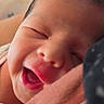 Eliana is registered to the contest to win money with this photo: newborn, baby, infant, sleeping, yawning, face, portrait, close_up, indoors, warm_lighting, adult_hand, support, dark_hair, closed_eyes, open_mouth, nose, cheeks, soft_focus, cozy, photograph