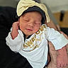 Eliana joined the competition — help win amazing prizes! newborn, baby, sleeping, infant, portrait, closeup, face, child, indoors, white_clothing, bow, headband, onesie, cradled, adult_arm, peaceful, soft_lighting, baby_fashion, family, photography