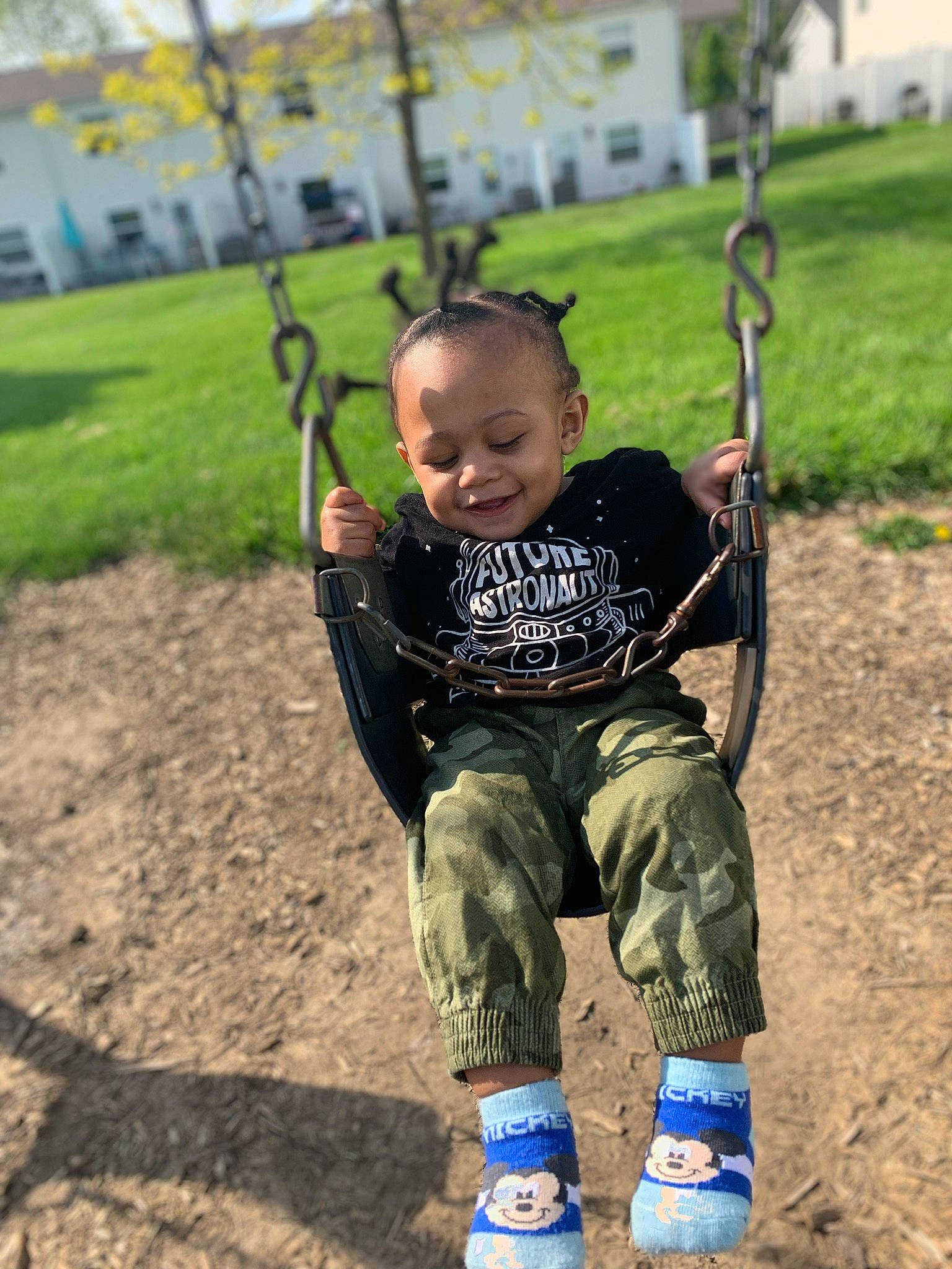 Messiah is registered to the contest to win money with this photo: child, city, fun, happy, joy, outdoor_play_equipment, person, play, playground, public_space, recreation, smile, swing, toddler, tree