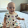 baby, child, smiling, dress, bed, blanket, window, crib, indoor, person, cute, happy, sitting, infant, mickey_mouse, pattern, room, light, clothing, playful