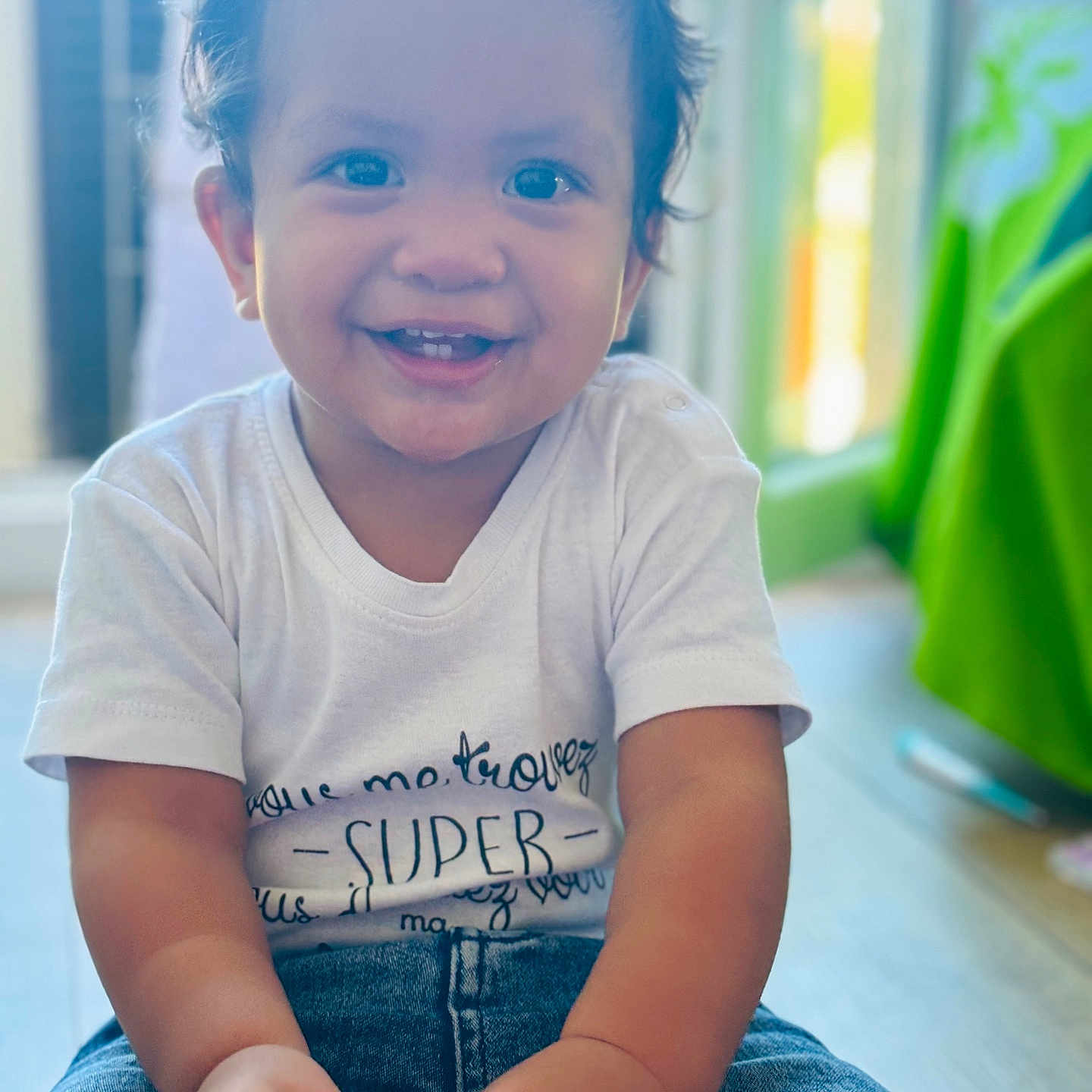Aaron a rejoint le concours — aidez-le/la à gagner de superbes lots ! baby, babylaughing, bodypart, clothing, face, happy, head, indoors, jeans, laughing, mouth, pants, person, photography, portrait, sitting, sleeve, smile, t_shirt, teeth