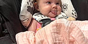 Hadley joined the competition — help win amazing prizes! baby, infant, car_seat, blanket, tongue_out, cute, child, seatbelt, patterned_fabric, pink, black, white, face, head, clothing, sitting, expression, indoor, soft, comfort
