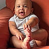 baby, child, clothing, couch, cute, expression, foot, furniture, hand, happy, indoors, infant, orange, person, portrait, relaxing, seated, short_sleeve, skin, smiling