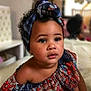 toddler, child, portrait, face, headwrap, colorful_clothing, indoor, curly_hair, looking_away, young_child, candid, beautiful, skin, expression, closeup, person, fashion, ethnic_wear, soft_lighting, baby