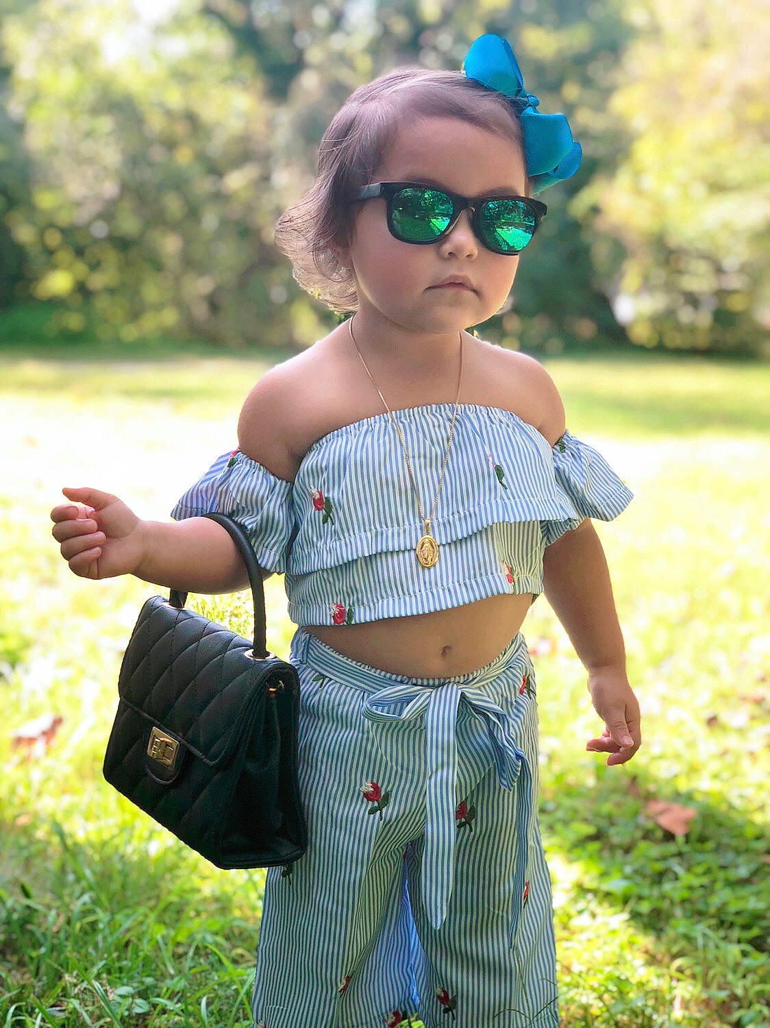 Lily Rose is registered to the contest to win money with this photo: child, clothing, crop_top, eyewear, glasses, grass, person, shirt, shoulder, smile, summer, sunglasses, toddler, top