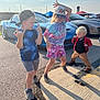 child, children, boy, girl, toddler, parking_lot, car, sports_car, sunny, daylight, asphalt, cap, shorts, sneakers, jacket, playful, posing, outdoor, fun, smiling