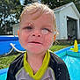 backyard, black, blue_sky, building, child, curious, daylight, face, grass, outdoor, playing, pool, shed, summer, swimwear, toddler, water, water_droplets, wet, yellow