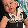 baby, infant, child, face, closeup, racing_outfit, checkered_flag, number_one, black_and_white, cute, soft_blanket, portrait, smiling, chubby_cheeks, young_child, indoors, clothing, hand, skin, expression