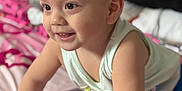 Adriel Romero is registered to the contest to win money with this photo: toddler, child, baby, crawling, smiling, indoors, bedspread, clothing, shorts, tank_top, happy, skin, hair, person, cute, playful, young_child, expression, face, hand