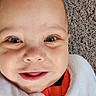 Jaxon is registered to the contest to win money with this photo: baby, bald, bib, blue_eyes, carpet, child, close_up, clothing, eyes, face, happy, indoor, infant, open_mouth, orange, photography, portrait, smiling, teeth, white_blanket