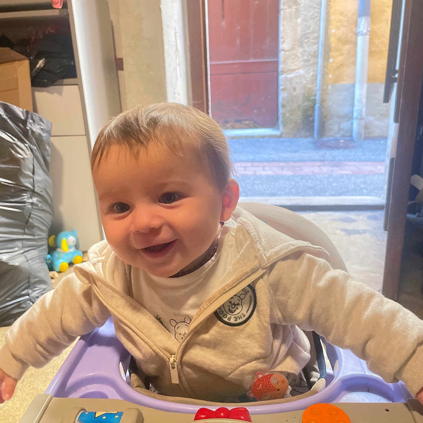 Giulio a rejoint le concours — aidez-le/la à gagner de superbes lots ! baby, baby_walker, background, child, clothing, colorful, face, floor, hair, happy, indoor, jacket, light, open_door, person, play, seat, smiling, toy, window