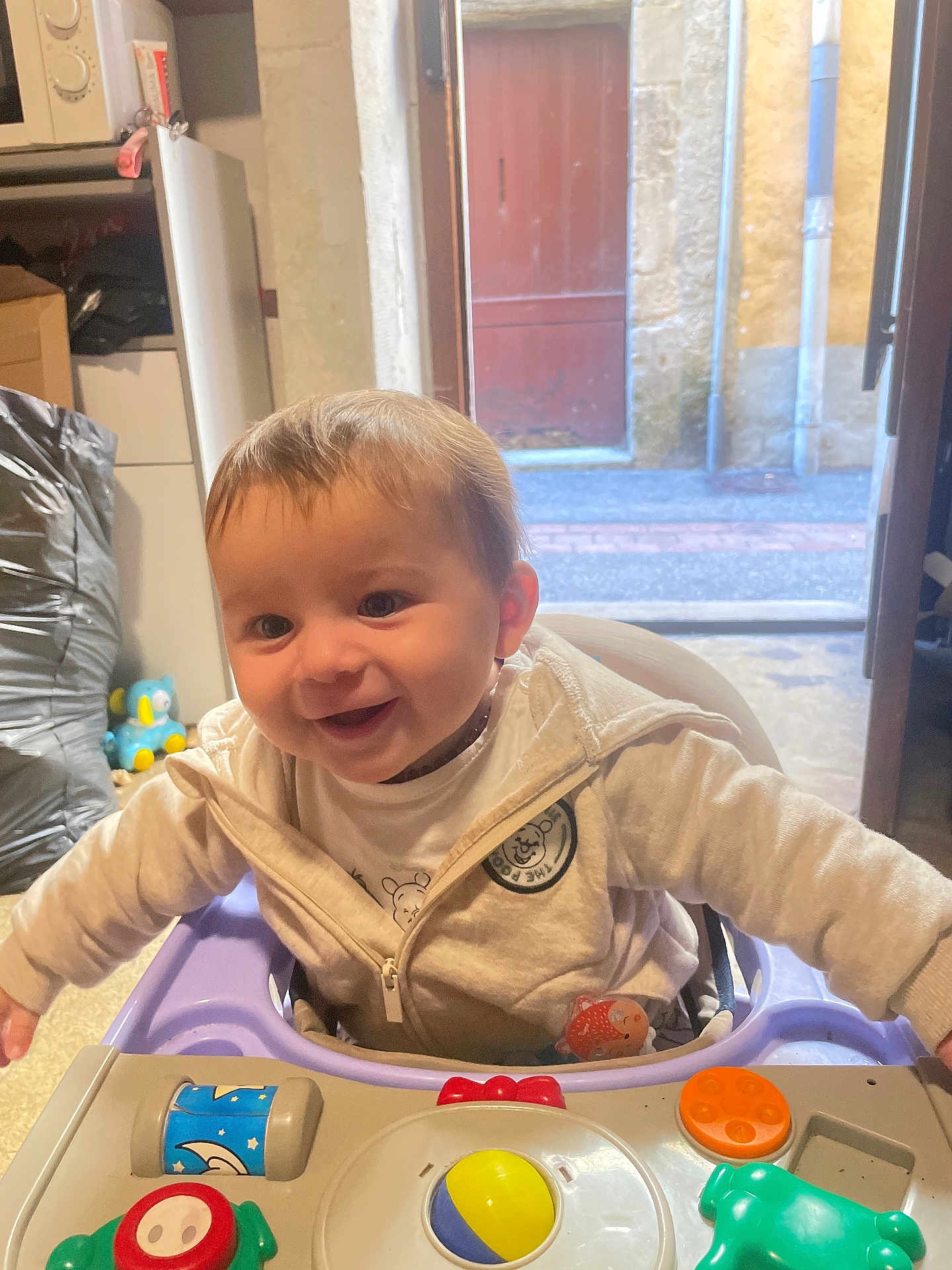 Giulio a rejoint le concours — aidez-le/la à gagner de superbes lots ! baby, child, smiling, indoor, baby_walker, toy, clothing, jacket, face, happy, person, play, colorful, open_door, background, floor, window, light, hair, seat
