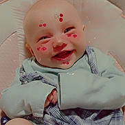 Rosalyn is registered to the contest to win money with this photo: baby, smiling, face, digital_stickers, cherry_stickers, clothing, diaper, cushion, pink, happy, infant, portrait, indoor, cute, child, sitting, soft_fabric, plaid, long_sleeve, closeup