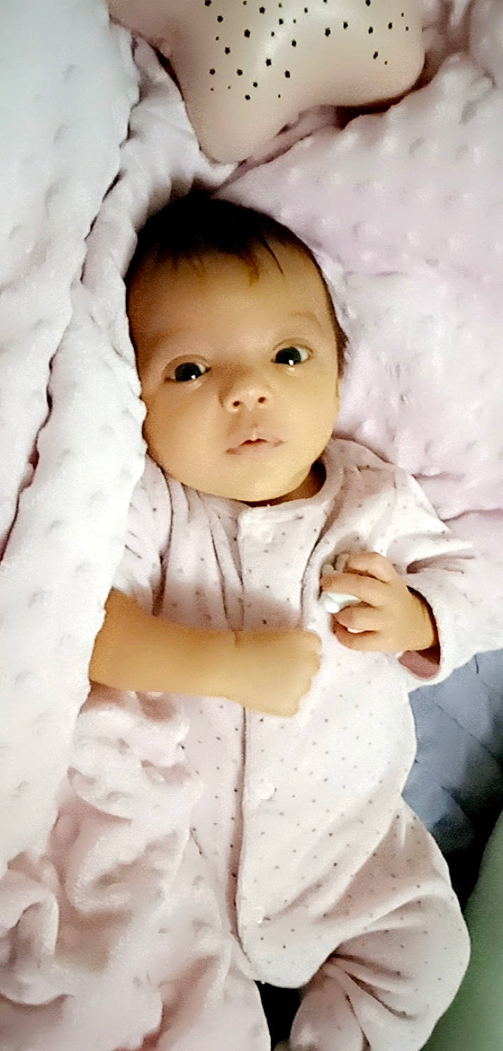 Laure participe au concours pour gagner de l'argent avec cette photo : baby, baby_toddler_clothing, cheek, child, collar, comfort, eyebrow, eyelash, flash_photography, gesture, happy, human, iris, linens, lip, nose, pattern, person, skin, sleeve