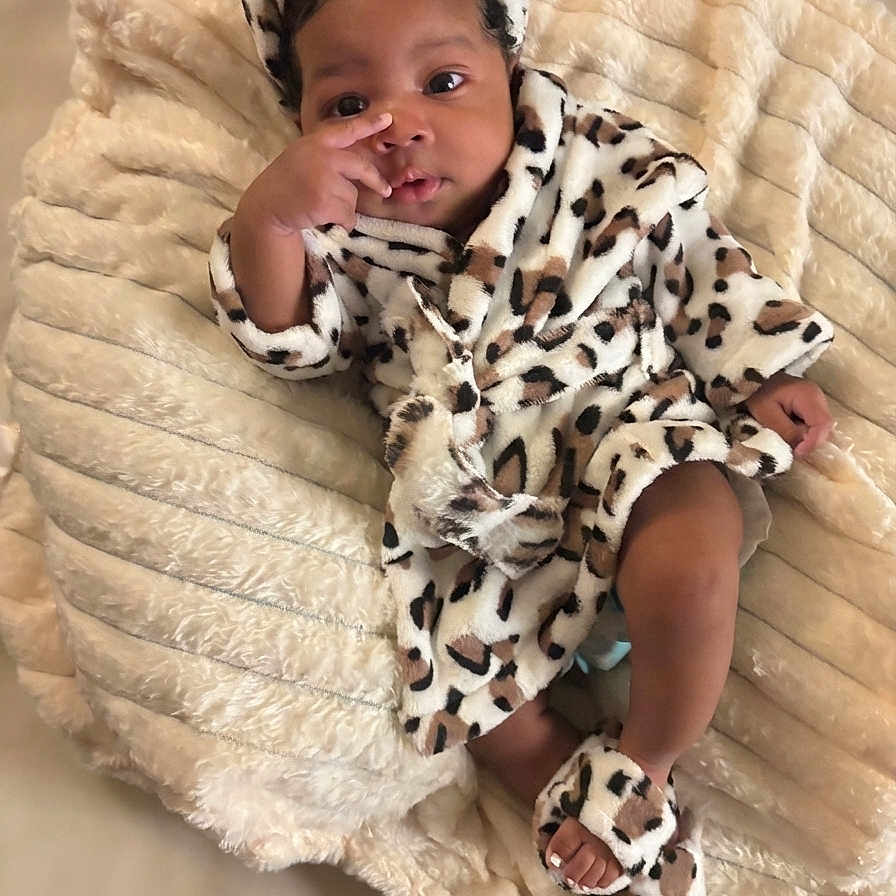 Dynastii is registered to the contest to win money with this photo: baby, blanket, child, comfort, cozy, cute, expression, fingers, headwrap, indoor, infant, leopard_print, portrait, relaxed, robe, sleepwear, slippers, small_feet, soft_texture, warm