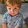 toddler, child, portrait, face, blue_eyes, red_hair, shirt, patterned_clothing, sitting, indoor, soft_light, curious_expression, cute, young_child, close_up, person, baby, skin, hair, eyebrows