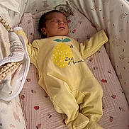 Eline participe au concours pour gagner de l'argent avec cette photo : baby, sleeping, onesie, yellow_clothing, bassinet, blanket, patterned_bedding, infant, cozy, cute, resting, newborn, child, indoor, soft_toys, peaceful, portrait, cute_baby, nursery, sleep