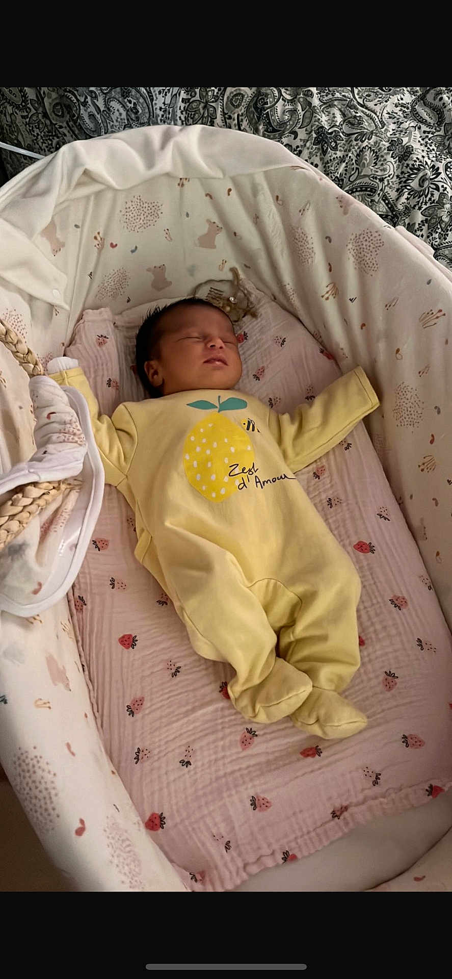Eline participe au concours pour gagner de l'argent avec cette photo : baby, sleeping, onesie, yellow_clothing, bassinet, blanket, patterned_bedding, infant, cozy, cute, resting, newborn, child, indoor, soft_toys, peaceful, portrait, cute_baby, nursery, sleep
