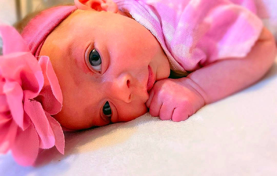 Blakelynn joined the competition — help win amazing prizes! baby, baby_toddler_clothing, cheek, close_up, comfort, eyebrow, eyelash, face, finger, grass, happy, headwear, lip, magenta, mouth, nail, nose, person, petal, pink